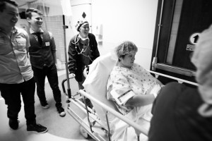 Mark and Jeff follow as Tami gets pushed into the operation room for surgery.