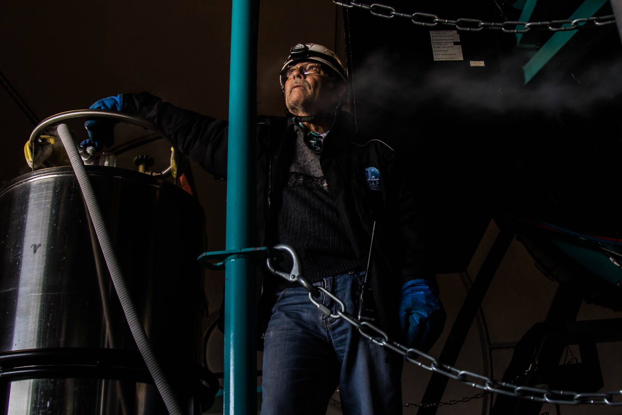 Once a month the SOAR team cleans the lens of the telescope with refrigerated nitrogen gas. Patricio Ugarte twists the nozzle to release the gas from the container. “You have to be very, very careful. The gas is about -400°F. It could really really hurt you if you aim it in the wrong direction.” Despite this fact, Ugarte stands calmly facing the other direction, away from the deadly gas, watching the sun set from the telescope’s shutter. “This is one of the best views, you got to take it in even if you’re working,” he says. 