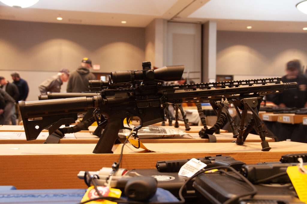 A modern "black" gun sits on display on a vendor's table.