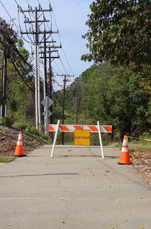 A construction road sign in the middle of a trail.