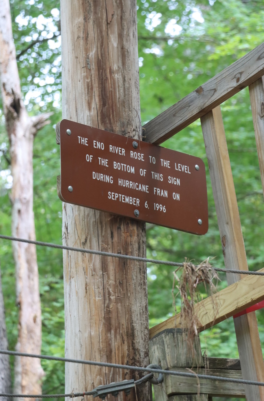 A brown sign posted on a tree.
