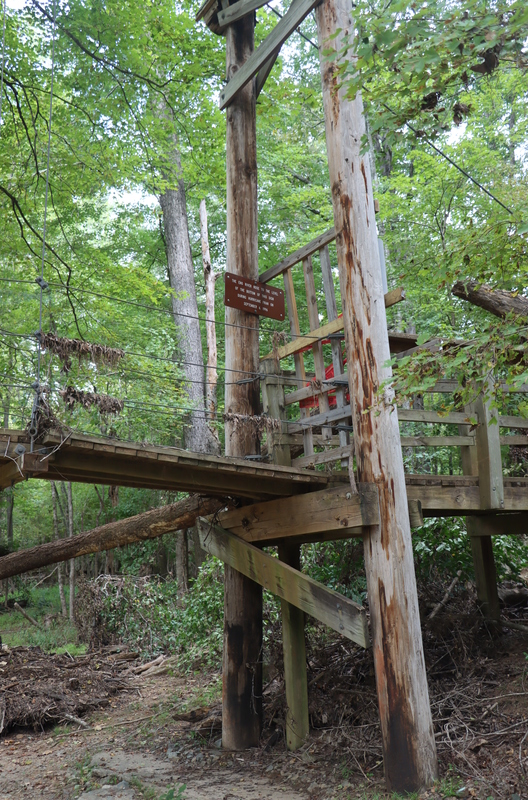 A bridge with one pole that has a brown sign on it.