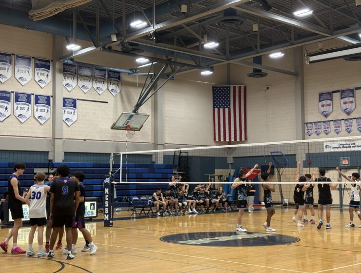 North Carolina School of Science and Mathematics boys volleyball team plays against Triangle Math and Science Academy boys volleyball team in a high school gym.