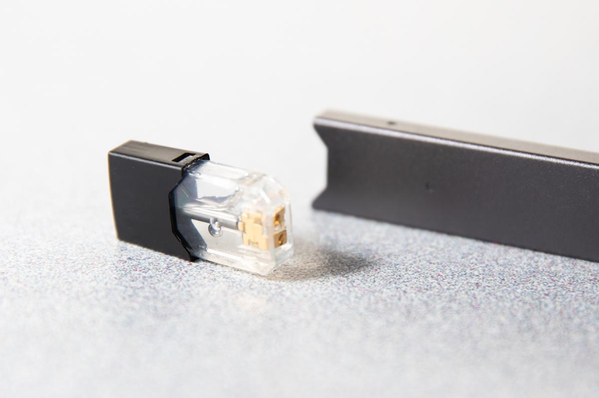 The flavor cartridge is a small black removable cap that fits in the top of the Juul. They are sold in many flavors.